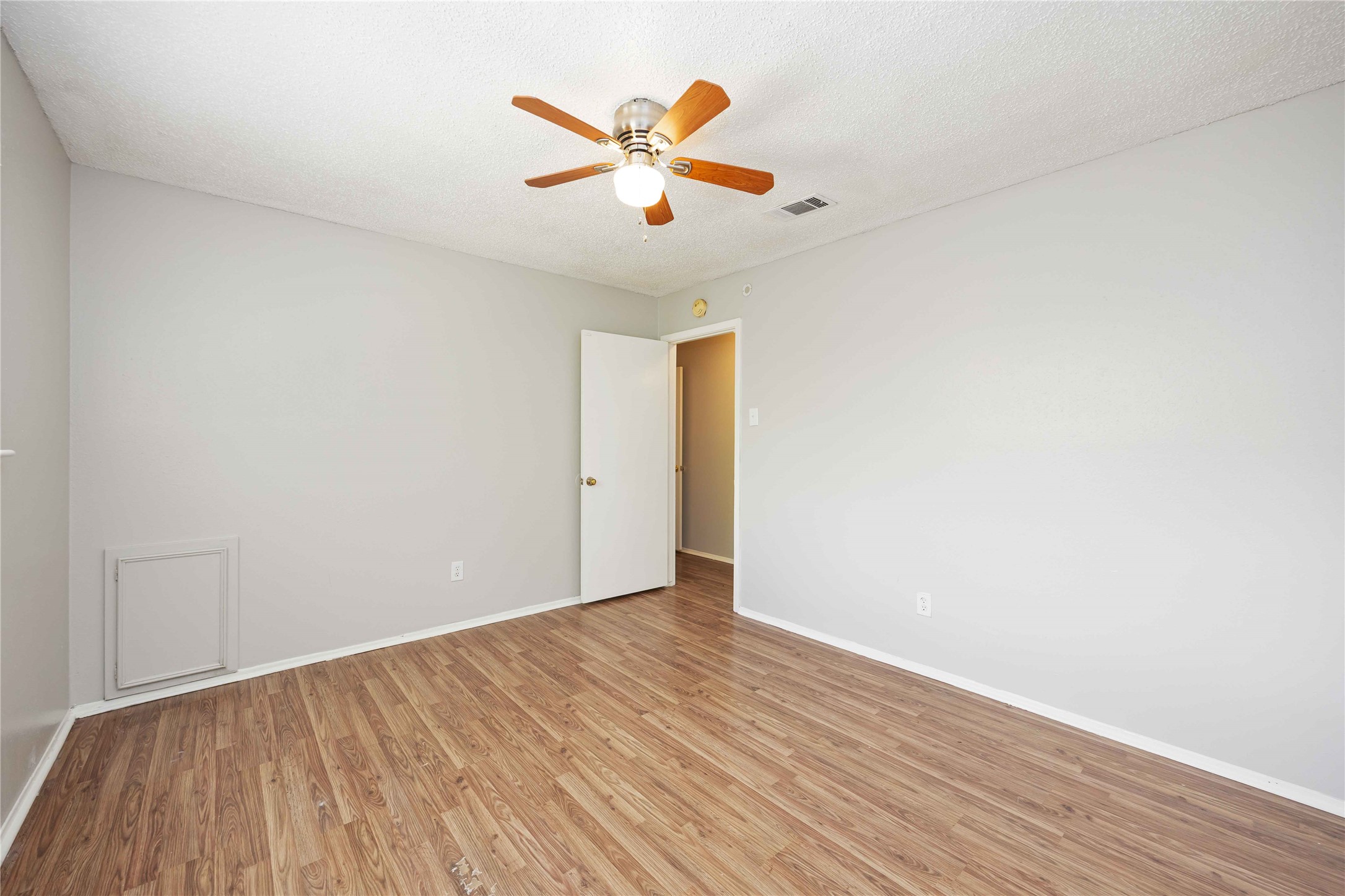 11750 Murr Way Houston, TX 77048 - Photo 14 of 23 an empty room with wooden floor and ceiling fan