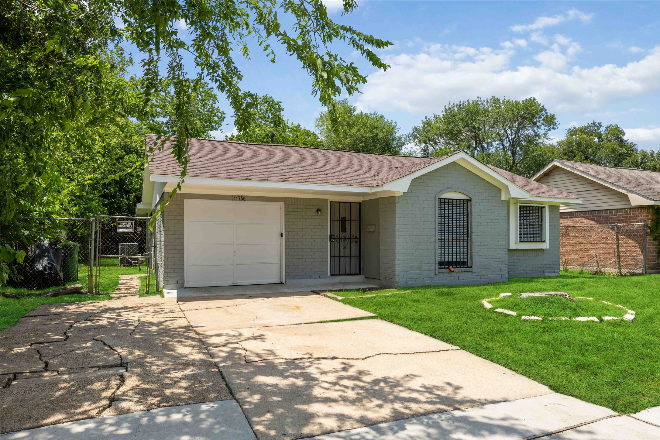 11750 Murr Way Houston, TX 77048 - Photo 2 of 23 a view of a yard in front of a house with plants and large tree