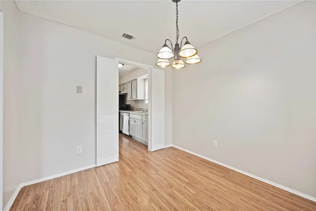 a view of a room with wooden floor and kitchen