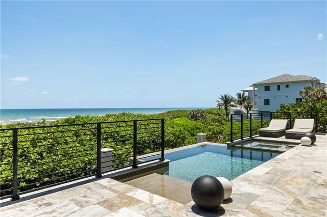 a front view of a house with a yard and lake view