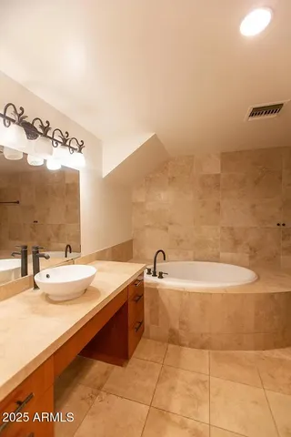 a bathroom with a tub sink and mirror