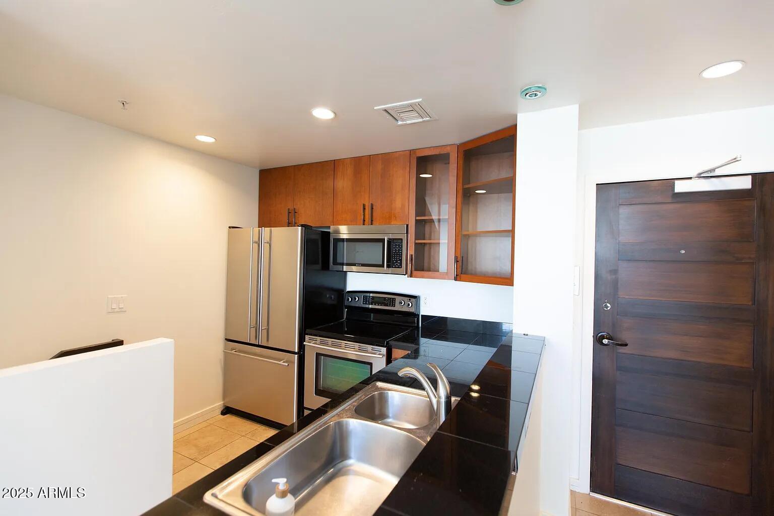 215 East McKinley Street, Unit 408 Phoenix, AZ 85004 - Photo 7 of 19 a kitchen with a refrigerator and a stove top oven