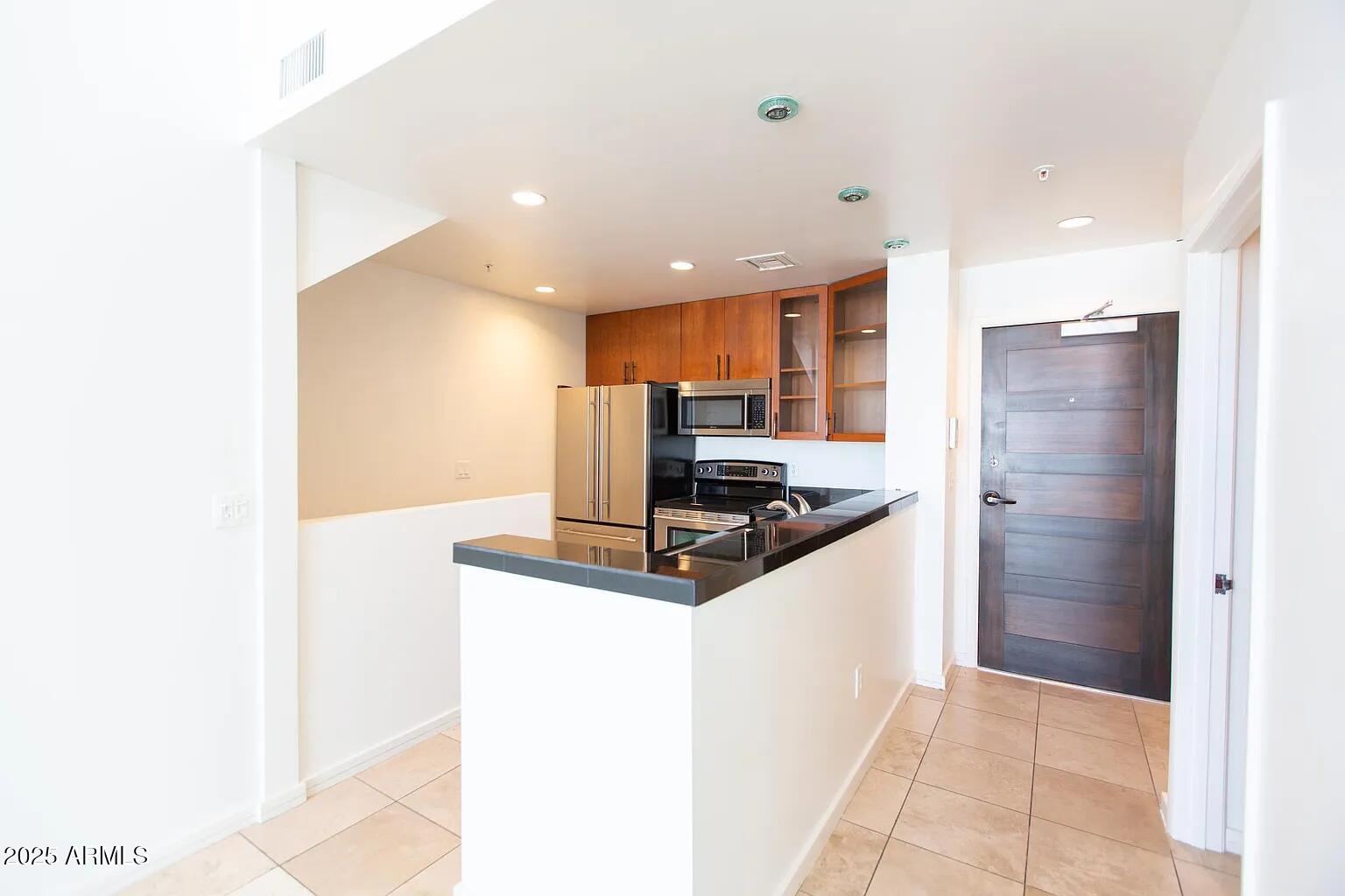 215 East McKinley Street, Unit 408 Phoenix, AZ 85004 - Photo 8 of 19 a kitchen with stainless steel appliances granite countertop a refrigerator and a sink