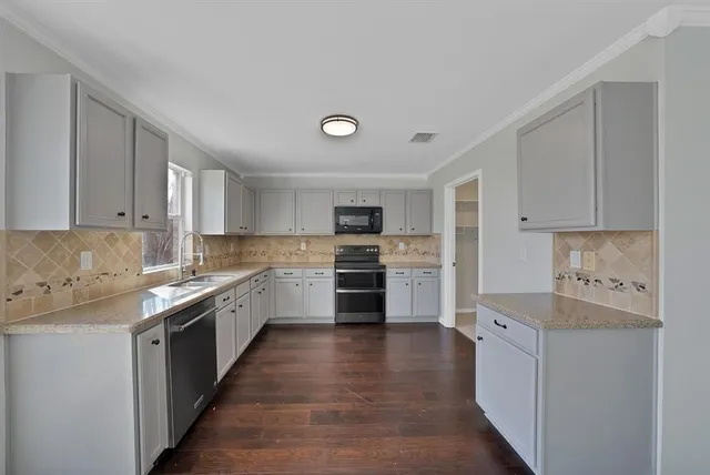 a kitchen with cabinets stainless steel appliances and sink