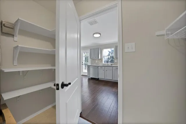 a view of an empty room with a fireplace and wooden floor