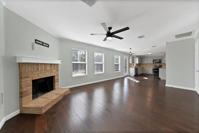 a view of empty room with wooden floor and fireplace