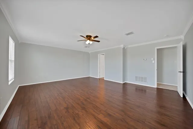 a view of an empty room with wooden floor