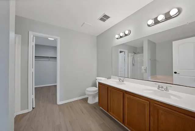 a spacious bathroom with a granite countertop sink mirror and toilet
