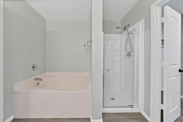 a white bath tub sitting next to a shower