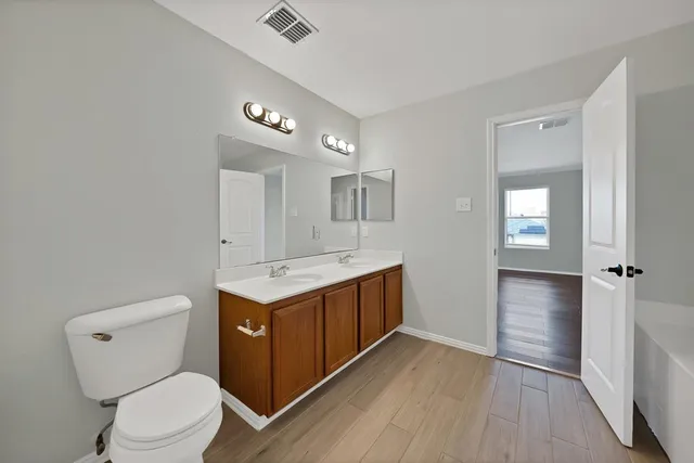 a bathroom with a granite countertop toilet sink and mirror