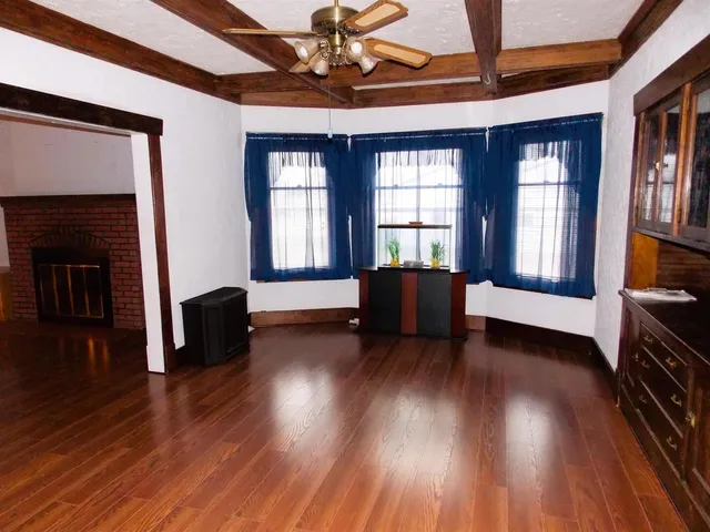a living room with couch wooden floor and a fireplace