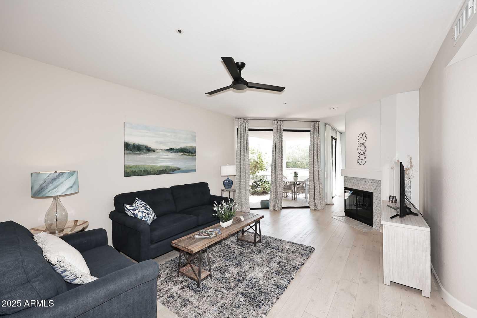 7700 East Gainey Ranch Road, Unit 128 Scottsdale, AZ 85258 - Photo 14 of 60 a living room with furniture and a fireplace