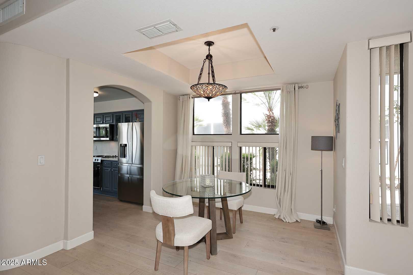 7700 East Gainey Ranch Road, Unit 128 Scottsdale, AZ 85258 - Photo 16 of 60 a dining room with furniture a chandelier and window