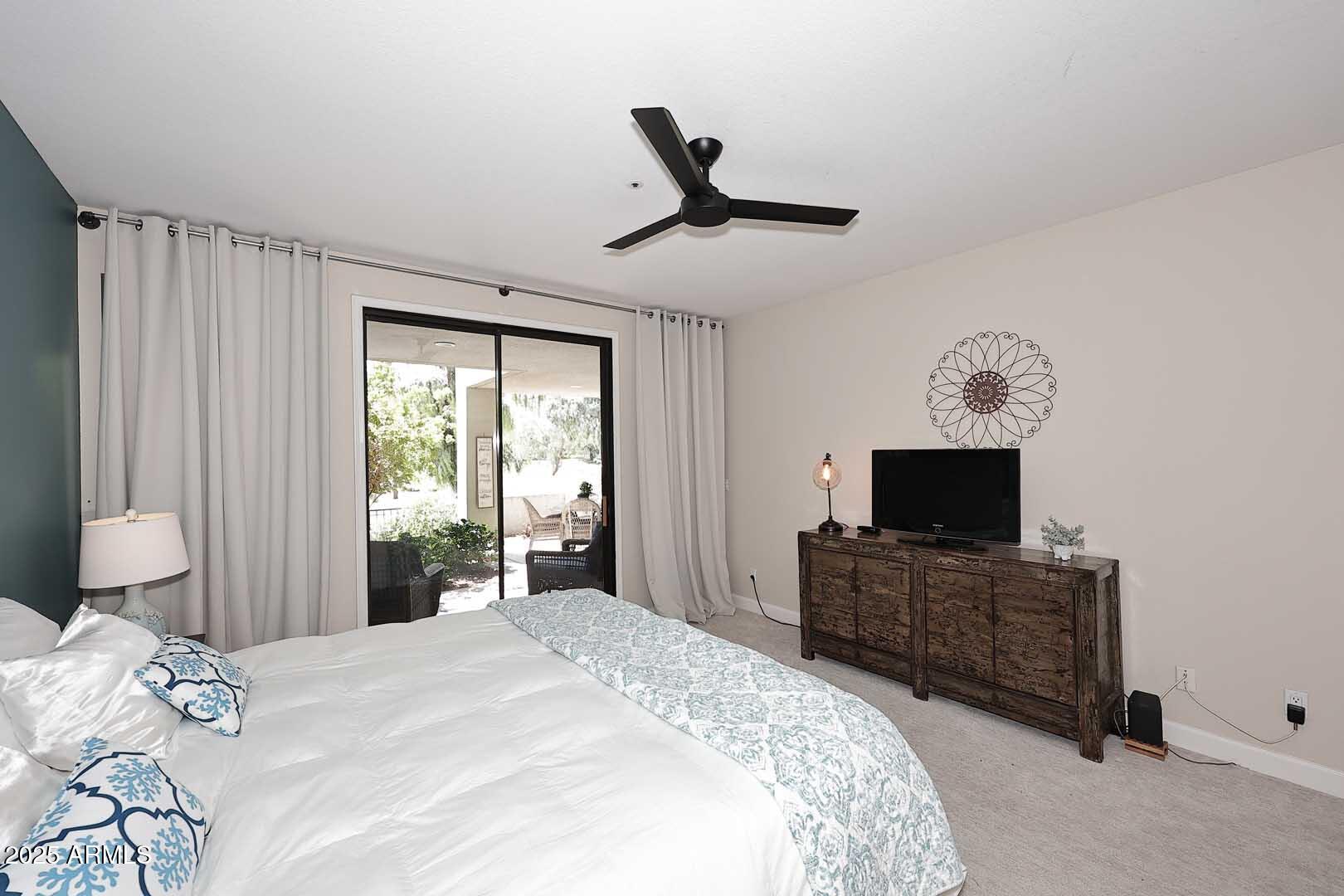 7700 East Gainey Ranch Road, Unit 128 Scottsdale, AZ 85258 - Photo 20 of 60 a bedroom with a bed and a flat screen tv