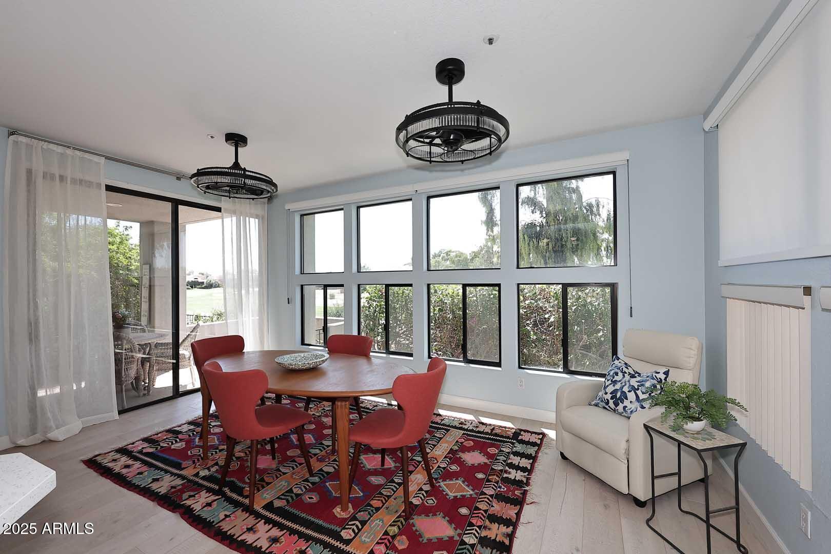 7700 East Gainey Ranch Road, Unit 128 Scottsdale, AZ 85258 - Photo 41 of 60 a dining room with furniture a large window and a rug