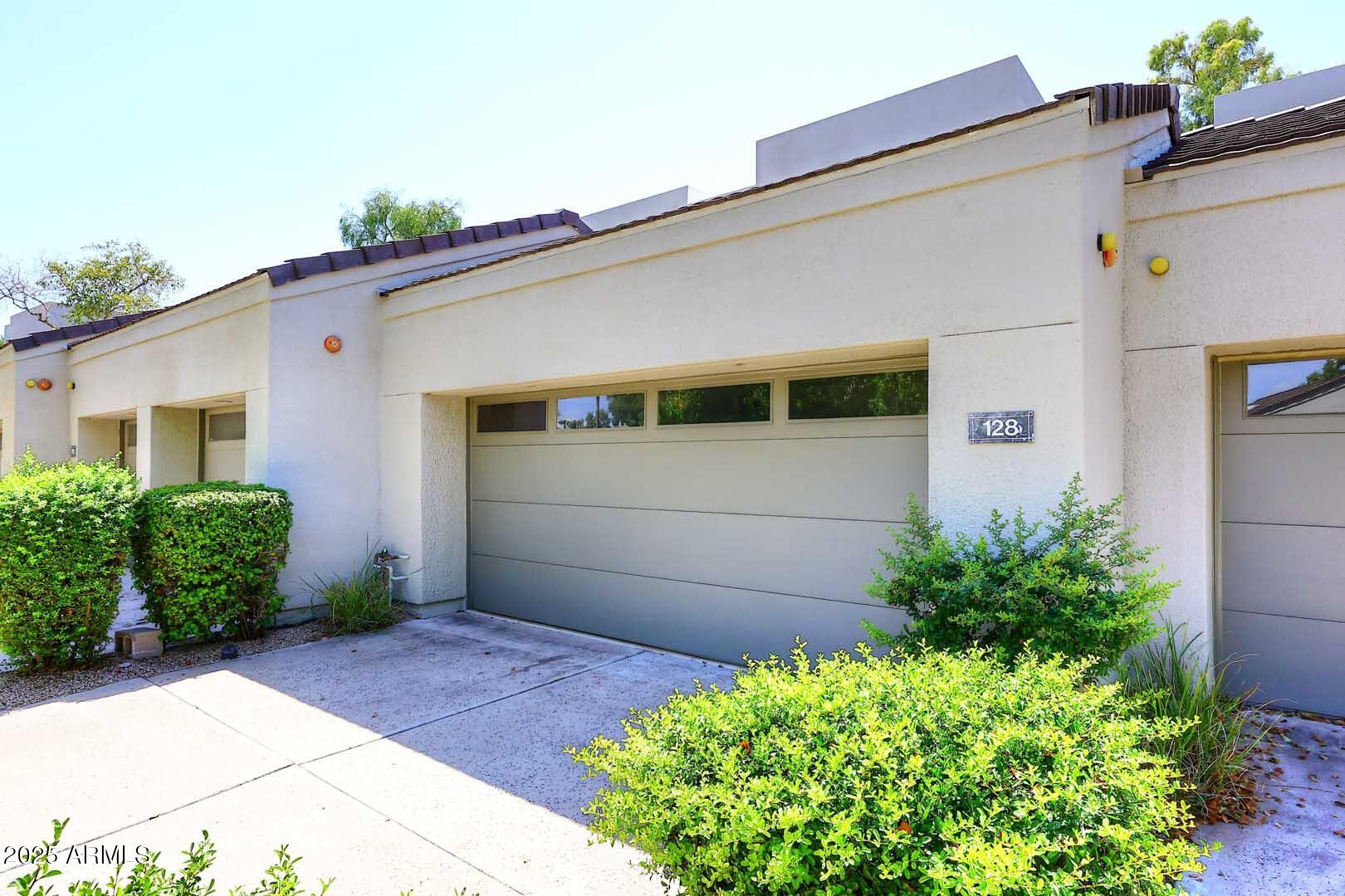 7700 East Gainey Ranch Road, Unit 128 Scottsdale, AZ 85258 - Photo 45 of 60 a front view of a house with a garden