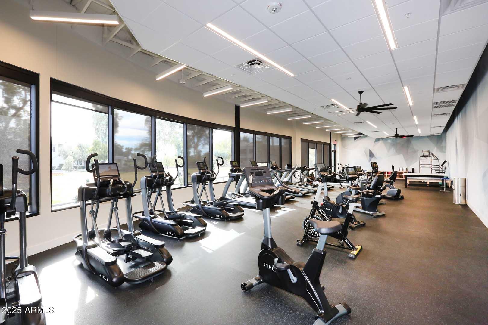 7700 East Gainey Ranch Road, Unit 128 Scottsdale, AZ 85258 - Photo 55 of 60 a room with gym equipment and large windows