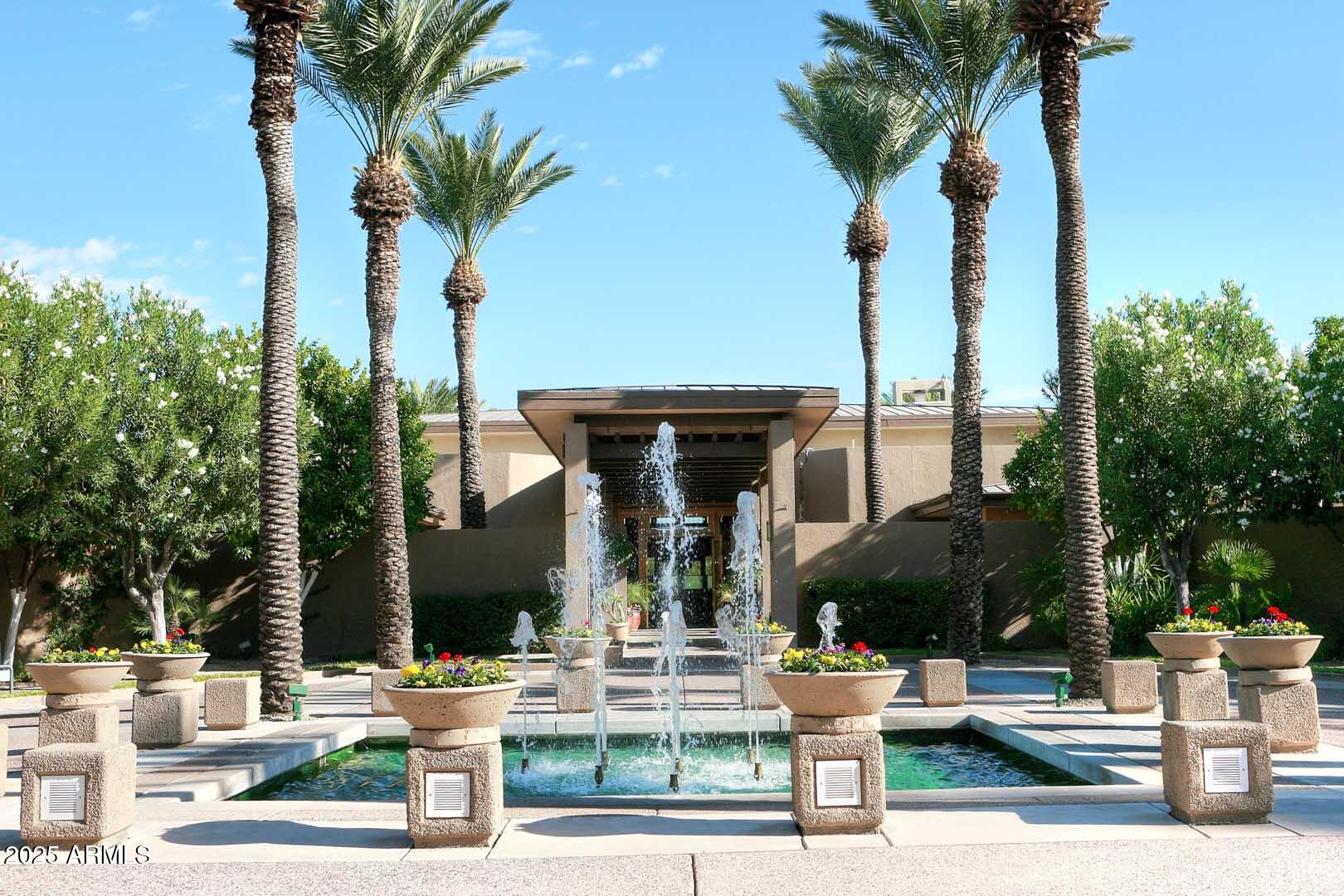 7700 East Gainey Ranch Road, Unit 128 Scottsdale, AZ 85258 - Photo 57 of 60 a view of a patio with table and chairs potted plants and palm trees