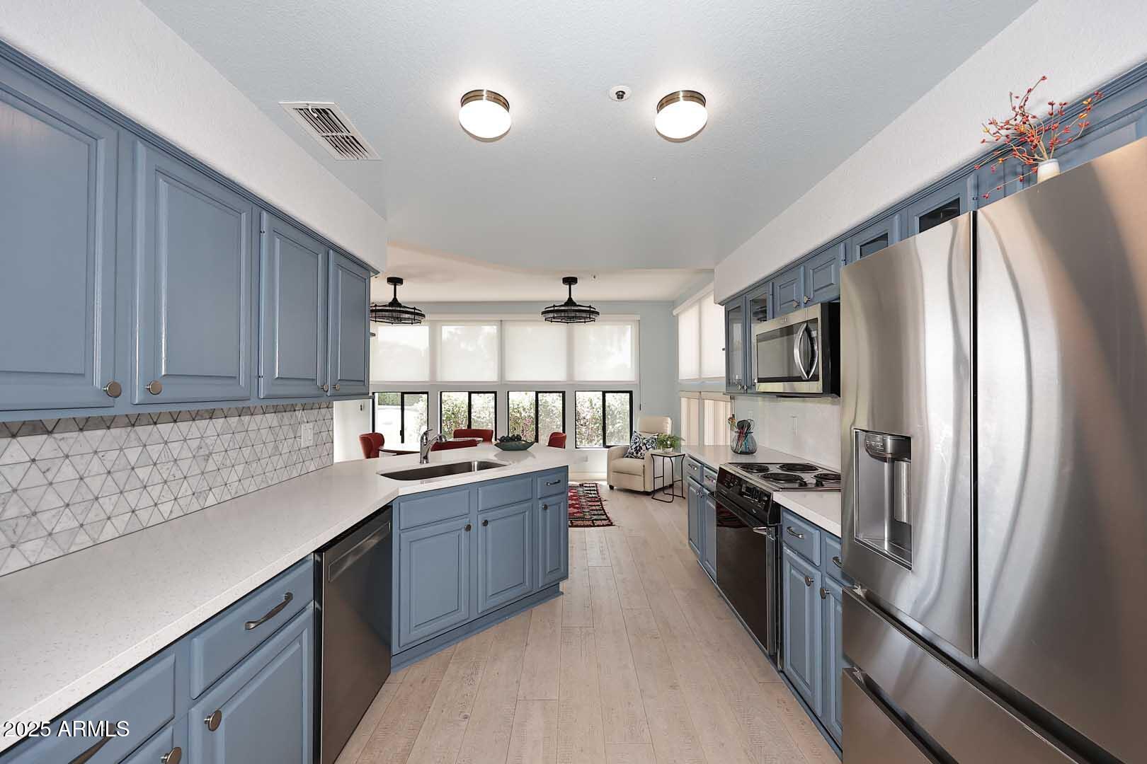 7700 East Gainey Ranch Road, Unit 128 Scottsdale, AZ 85258 - Photo 6 of 60 a kitchen with stainless steel appliances a sink stove and refrigerator