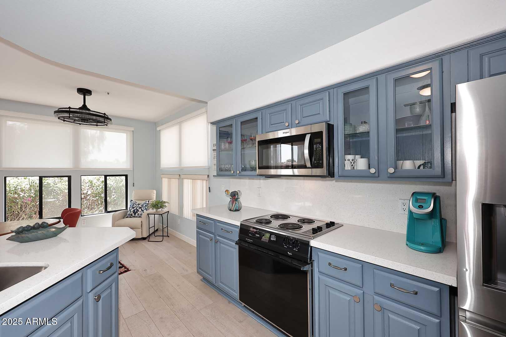 7700 East Gainey Ranch Road, Unit 128 Scottsdale, AZ 85258 - Photo 7 of 60 a kitchen with stainless steel appliances a sink stove and a refrigerator