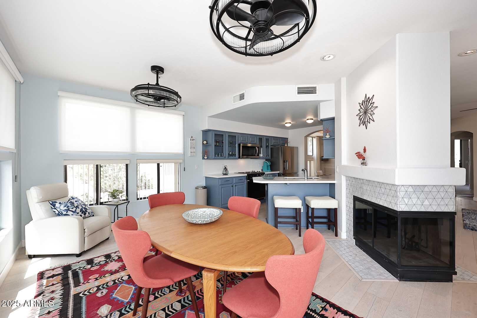 7700 East Gainey Ranch Road, Unit 128 Scottsdale, AZ 85258 - Photo 8 of 60 a living room with stainless steel appliances kitchen island granite countertop furniture and a fireplace