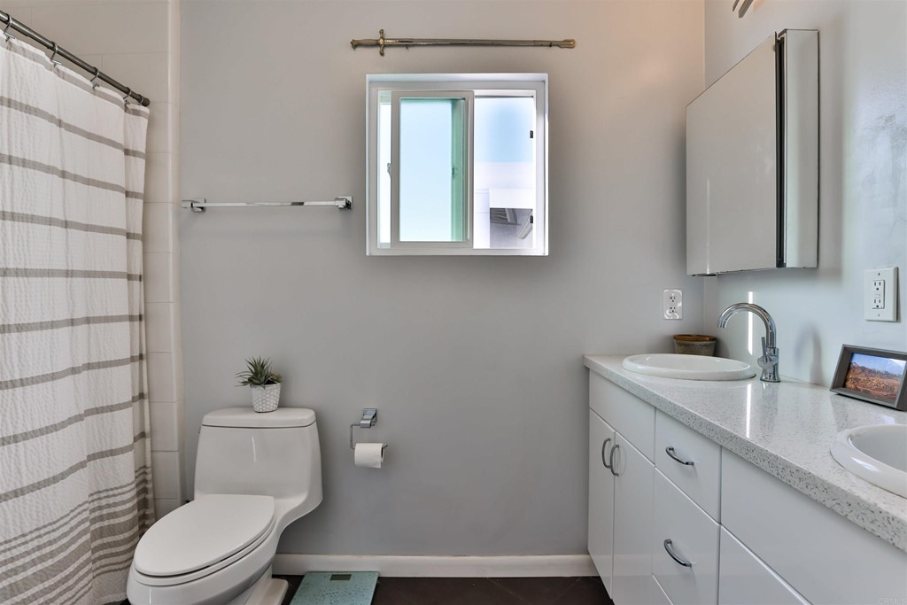 1116 Third Street Coronado, CA 92118 - Photo 15 of 33 a bathroom with a toilet a sink a vanity and mirror