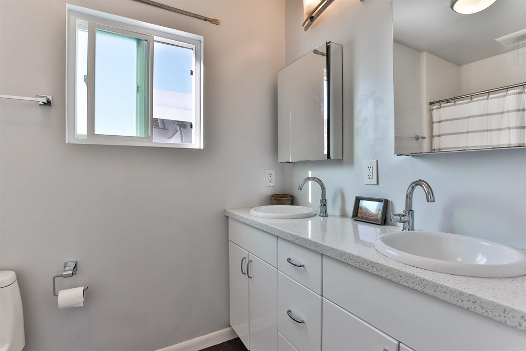 1116 Third Street Coronado, CA 92118 - Photo 16 of 33 a bathroom with a toilet sink and mirror