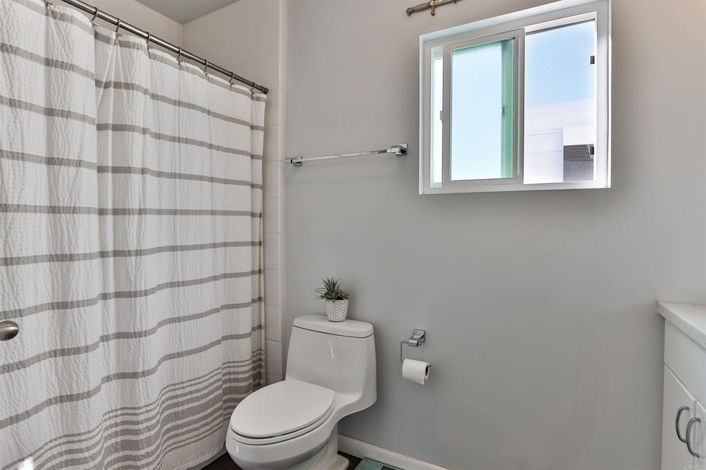 1116 Third Street Coronado, CA 92118 - Photo 17 of 33 a white toilet sitting next to a bathroom sink and a shower