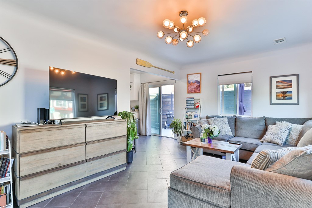1116 Third Street Coronado, CA 92118 - Photo 6 of 33 a living room with furniture a chandelier and a flat screen tv