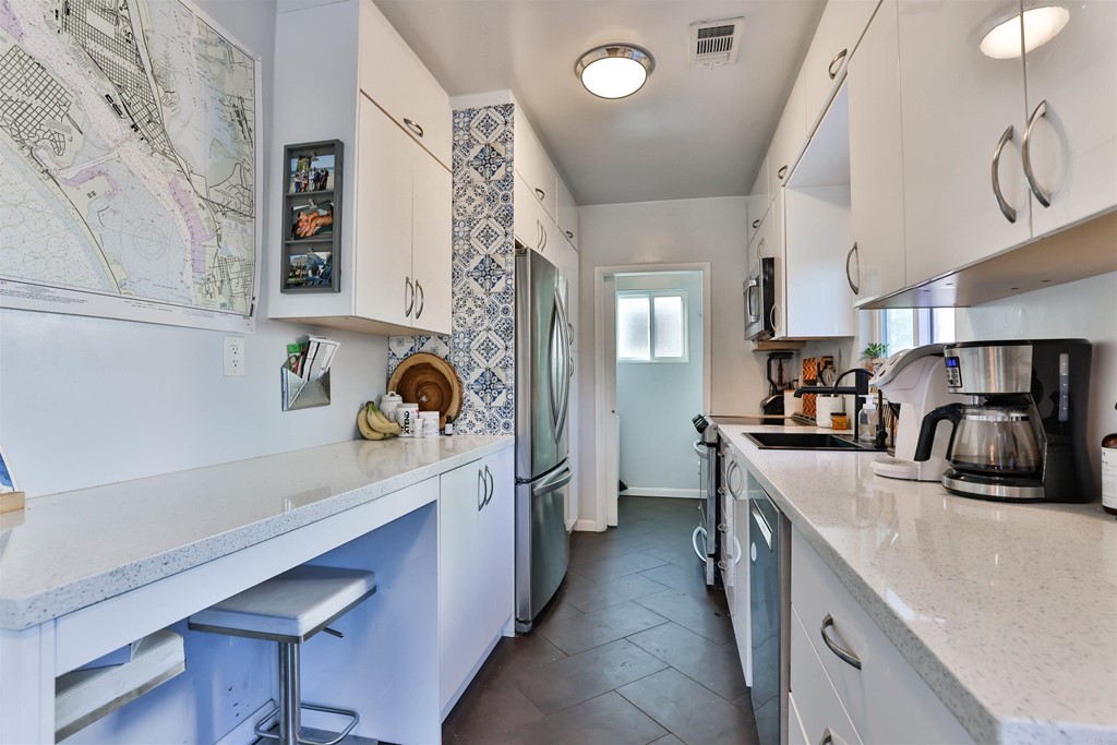 1116 Third Street Coronado, CA 92118 - Photo 8 of 33 a kitchen with stainless steel appliances a sink dishwasher a stove a refrigerator and a dining table with wooden floor