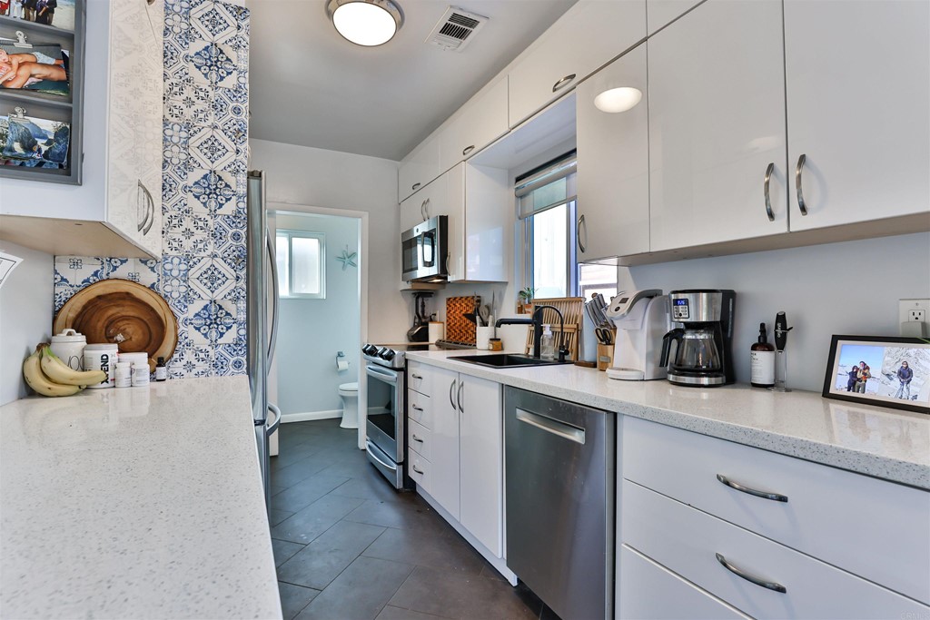 1116 Third Street Coronado, CA 92118 - Photo 10 of 33 a kitchen with stainless steel appliances granite countertop a sink and cabinets