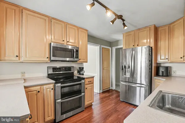 a kitchen with granite countertop a refrigerator stove and microwave