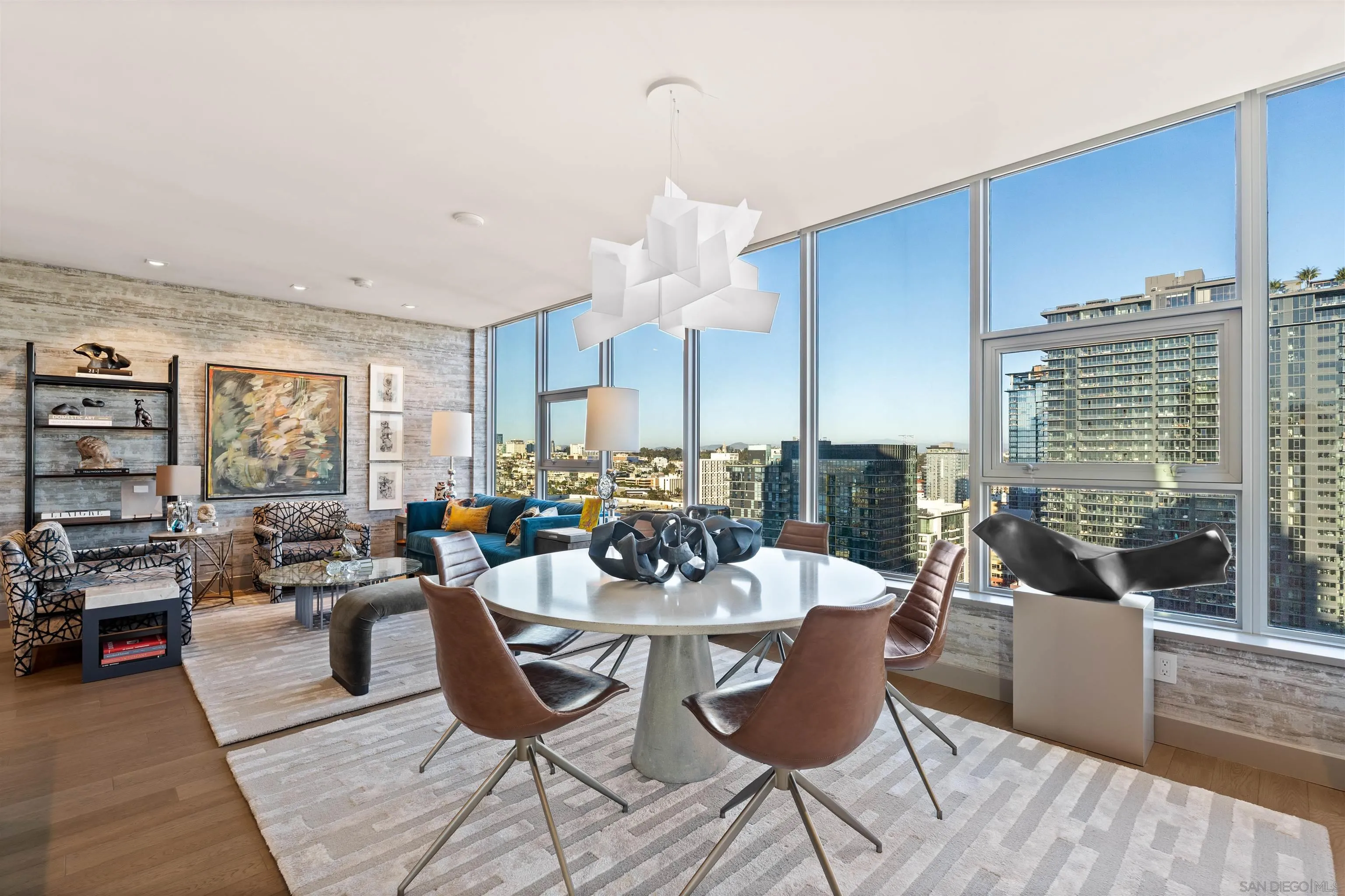 a living room with furniture large window and wooden floor