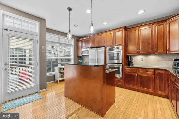 a kitchen with stainless steel appliances granite countertop a sink a stove and a refrigerator