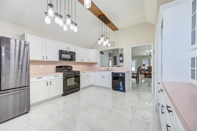 a kitchen with kitchen island granite countertop stainless steel appliances cabinets a sink and a counter top space