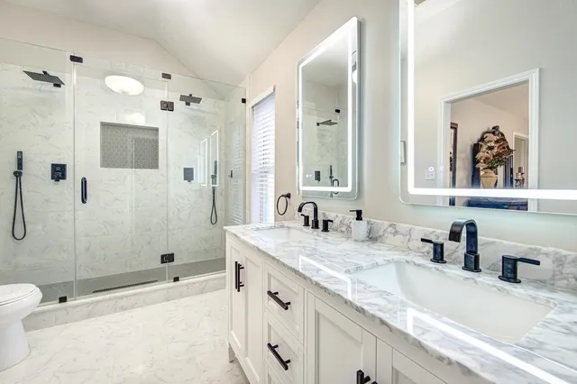 a bathroom with a granite countertop sink mirror and shower