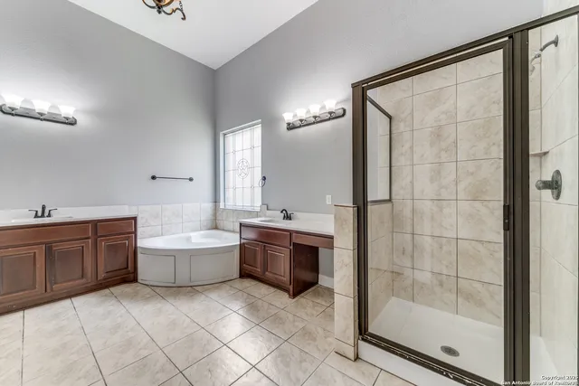 a large bathroom with a tub shower and sink
