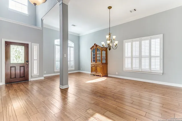a view of a room with wooden floor fireplace and windows