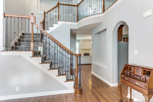 a view of staircase with lots of frames on wall and wooden floor
