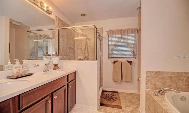 a bathroom with a granite countertop sink a mirror and shower