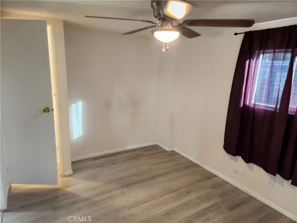 an empty room with wooden floor and entryway