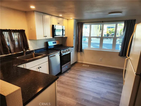 a kitchen with stainless steel appliances granite countertop a stove a sink and a refrigerator