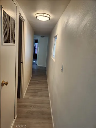 a view of a hallway with wooden floor and closet
