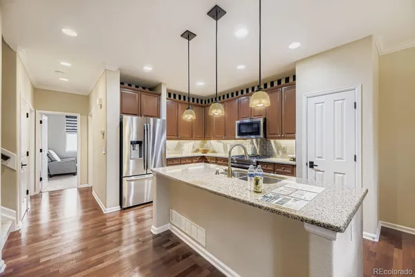 a kitchen with stainless steel appliances granite countertop a refrigerator a sink and a stove