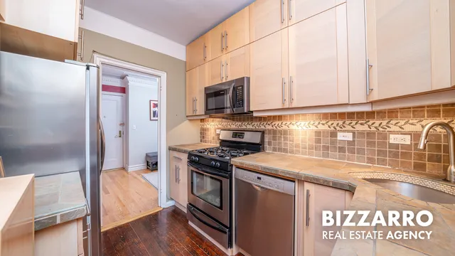 a kitchen with stainless steel appliances granite countertop a stove a sink and a microwave
