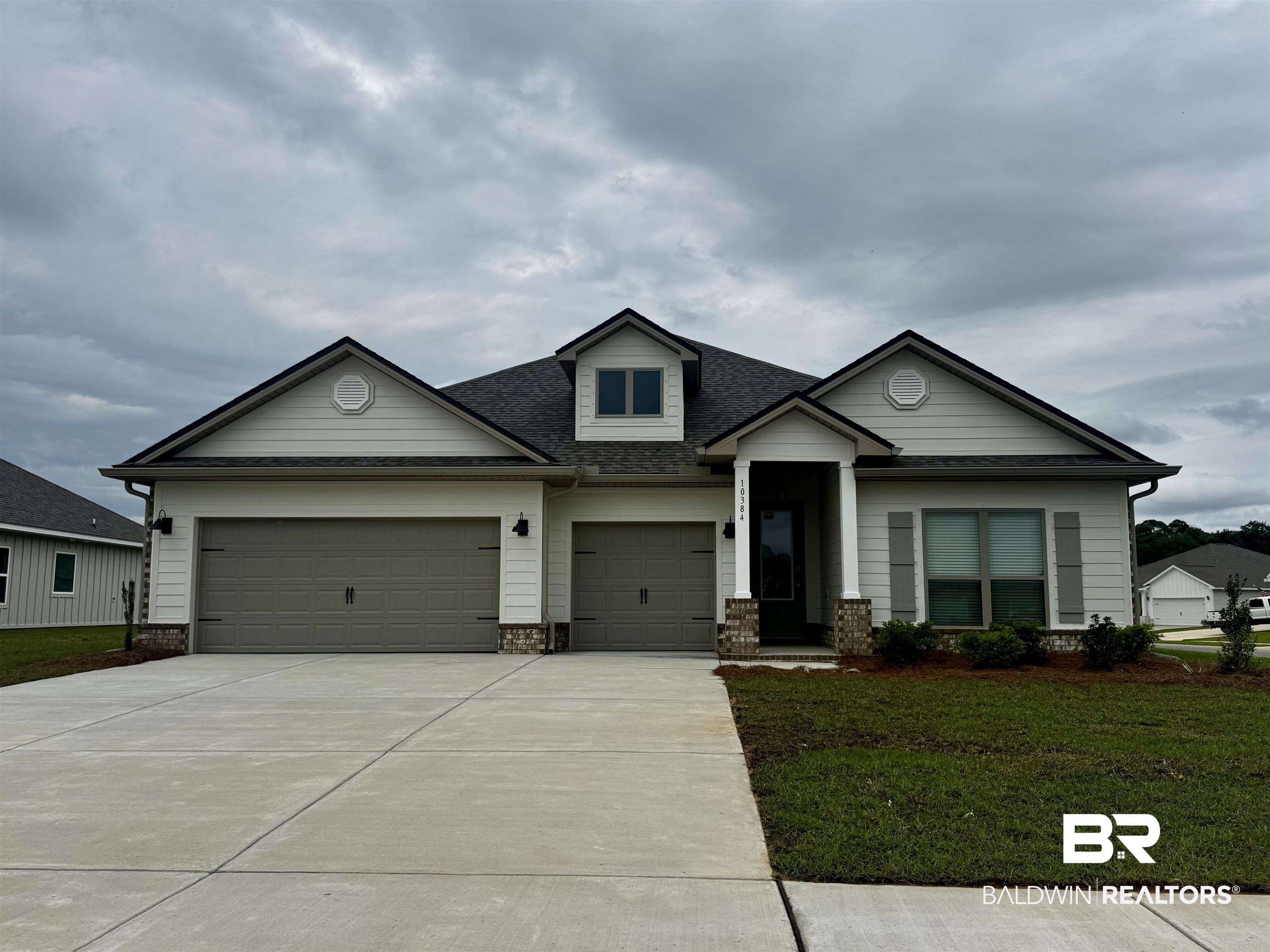 10384 Winning Colors Trail Daphne, AL 36526 - Photo 1 of 38 Inviting exterior featuring light-colored siding, dark roofing, and decorative stone accents