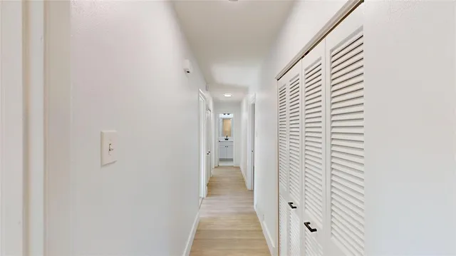 a view of a hallway with wooden shelves