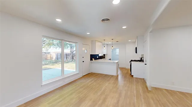 a large living room with stainless steel appliances wooden floors and view living room