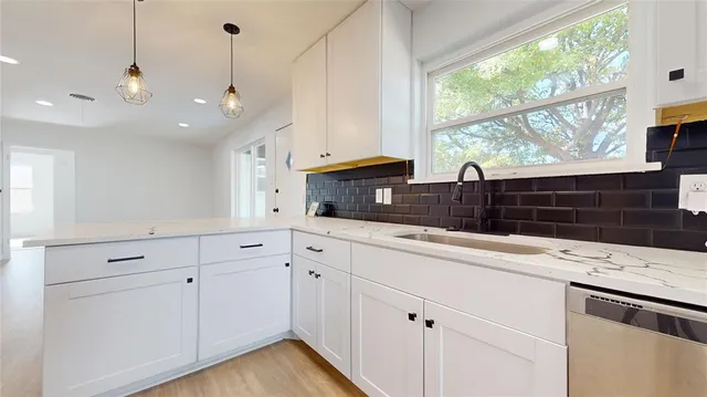 a kitchen with granite countertop white cabinets and white appliances