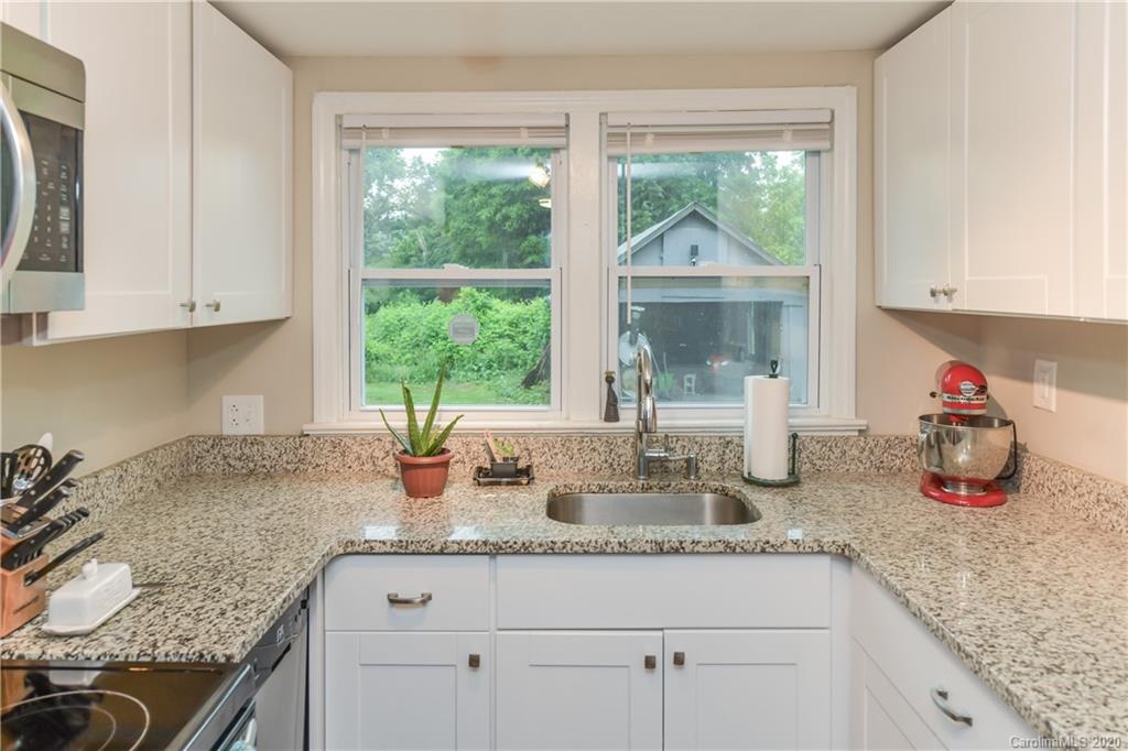 1239 Log Cabin Road Charlotte, NC 28213 - Photo 7 of 26 a kitchen with sink a window and cabinets